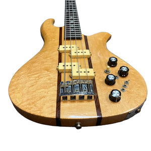 A 1982 USA-made B.C. Rich Eagle Bass with original electronics, striped natural wood finish, neck-through construction, three pickups, four knobs, and two toggles is photographed against a white background.