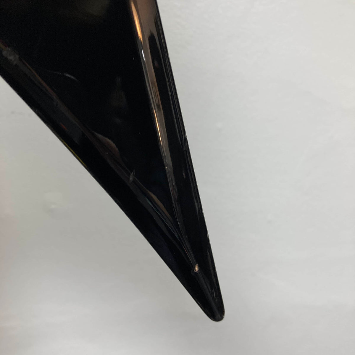 Close-up of a glossy black 1992 Carvin Ultra V USA with Kahler Steeler Trem and MJ‑wound Seymour Duncan DCJ, showing a small chip near the tip against a plain white background.