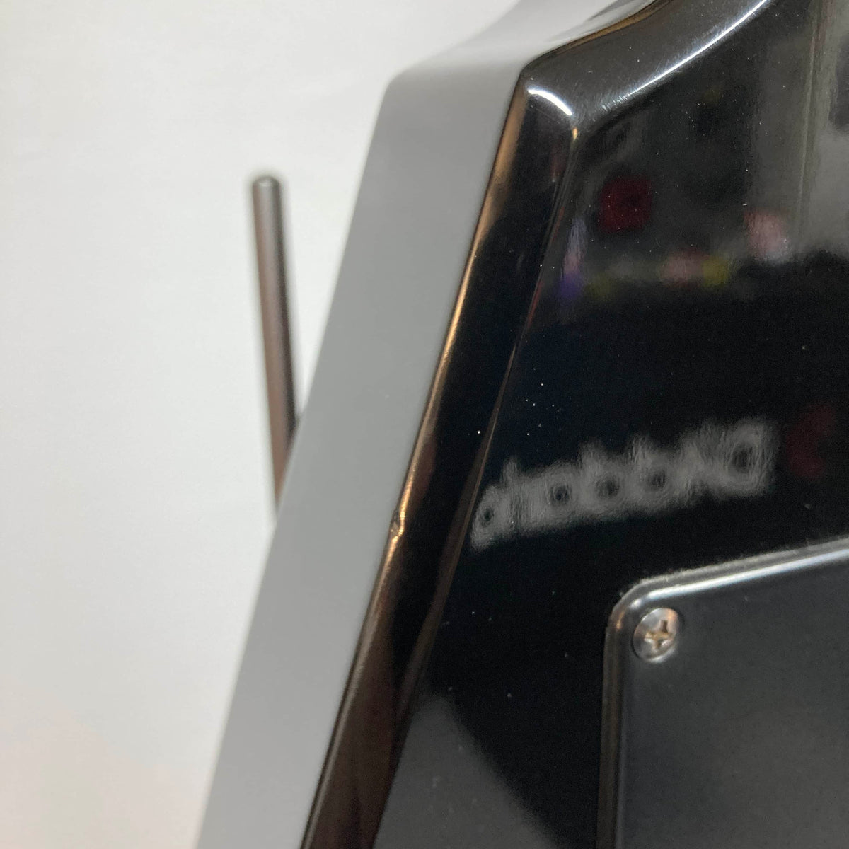 Close-up of a glossy black Carvin 1992 Ultra V USA, with a metal antenna and blurred reflection—echoing the precision of its Kahler Steeler Trem and MJ‑wound Seymour Duncan DCJ pickups.