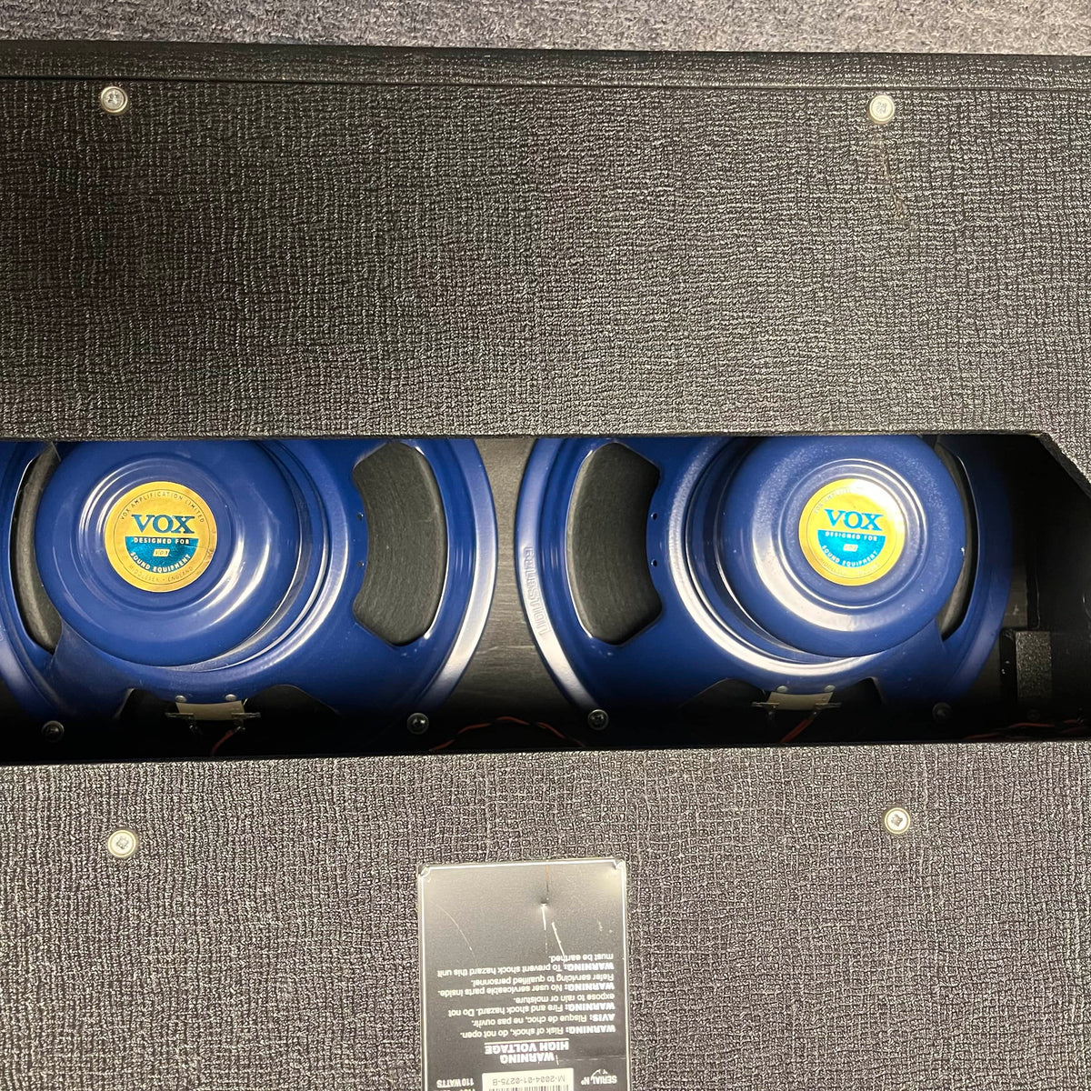 Rear view of a 2004 Vox AC30/6TB guitar amp by Vox, made in England, showing three Celestion Alnico Blues speakers through the open back of the black cabinet.
