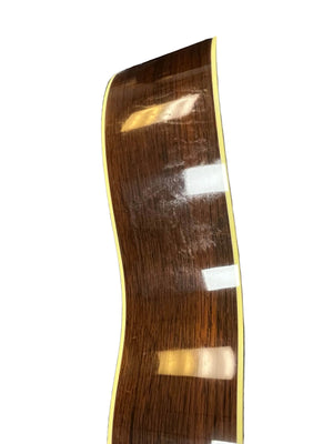 Side view of a 2005 Collings CJ BaA guitar, featuring a polished Brazilian rosewood body, yellow binding, Adirondack spruce top, and reflections of overhead lights.