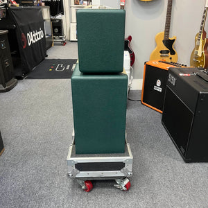 A 2005 Divided by 13 RSA 31 head with matching 2x12 cabinet and flight case is stacked on a rolling cart in a music store, surrounded by guitars and amplifiers. Local pickup for this Divided by 13 product is available.