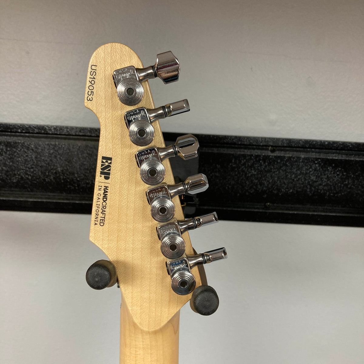 Close-up of the back of a 2019 ESP USA M-II Purple Haze Burst electric guitar headstock, highlighting six tuning pegs, serial number US190503, and ESP manufacturer details engraved on light wood. This American-made instrument exemplifies exceptional craftsmanship and includes a matching case.