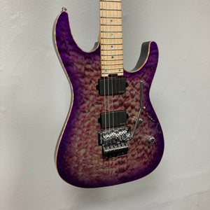 The ESP 2019 USA M-II Purple Haze Burst electric guitar features a breathtaking quilted maple top finished in Purple Haze Burst, a maple neck, dual humbucker pickups, and a Floyd Rose tremolo system. This American-made ESP model is shown photographed against a plain light-colored wall and comes complete with its case.
