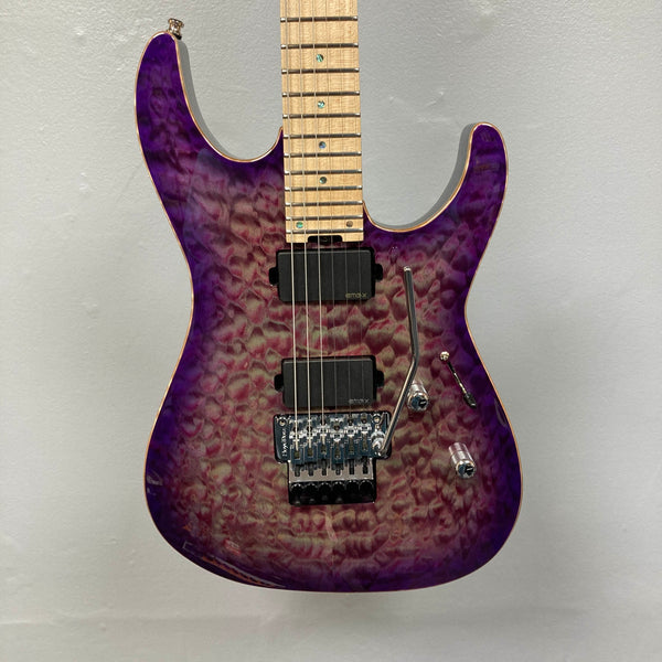 The 2019 ESP USA M-II Purple Haze Burst w/Case, crafted in the USA by ESP, features a stunning quilted maple top in Purple Haze Burst, two black humbucker pickups, a maple fretboard, and a Floyd Rose tremolo bridge—photographed here against a plain light gray wall.