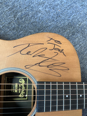 Body of a Martin 00X1AE Acoustic-Electric Guitar with a Richie Kotzen autograph in black marker on the solid spruce top.