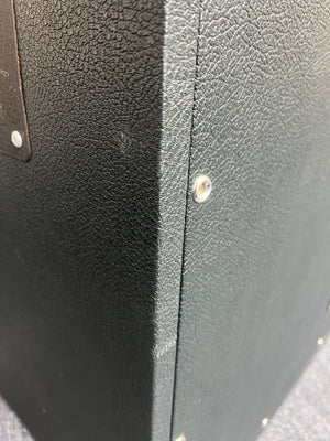 Close-up of a black textured box or case featuring visible metal screws on the corners and side panels, reminiscent of the rugged design found on a vintage 1969 Marshall 4x12 Cabinet with Matching Celestion T1281 Greenbacks and classic basketweave grille cloth.