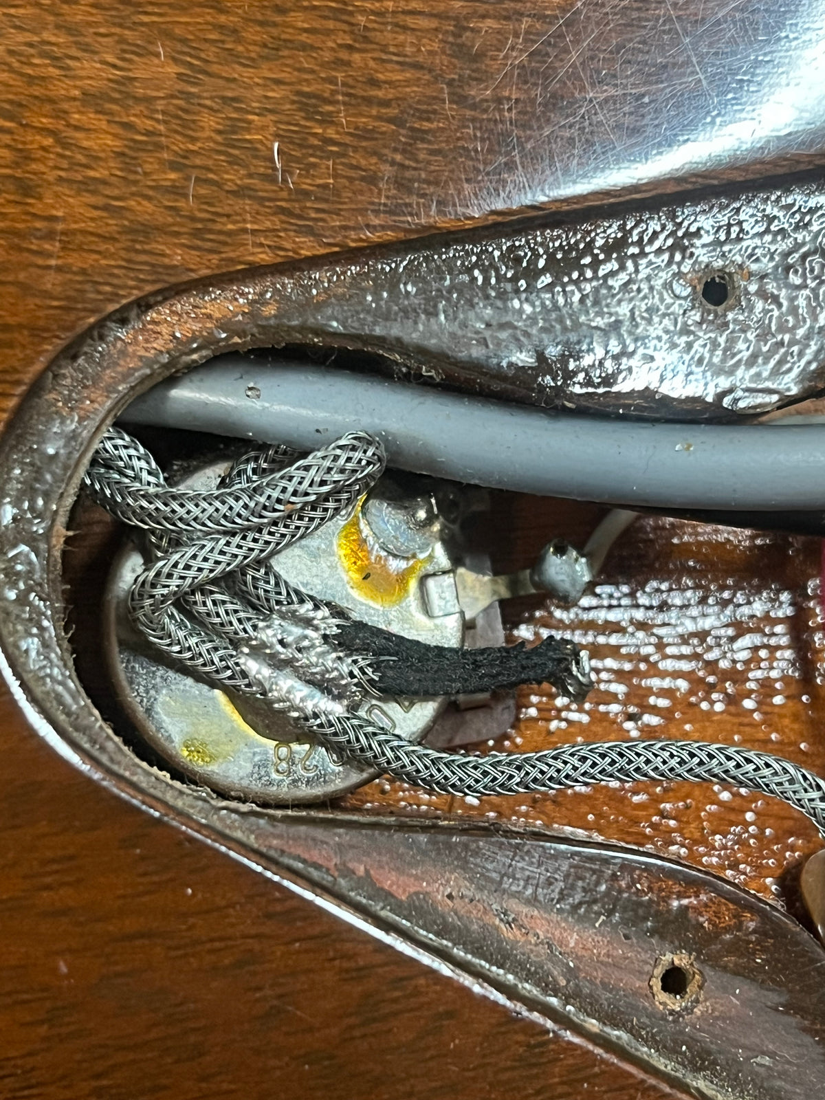 Close-up of the internal cavity of a Gibson 1978 EDS-1275 Double Neck Walnut w/Case, displaying wiring, a potentiometer, and braided cables set against the wood grain body.