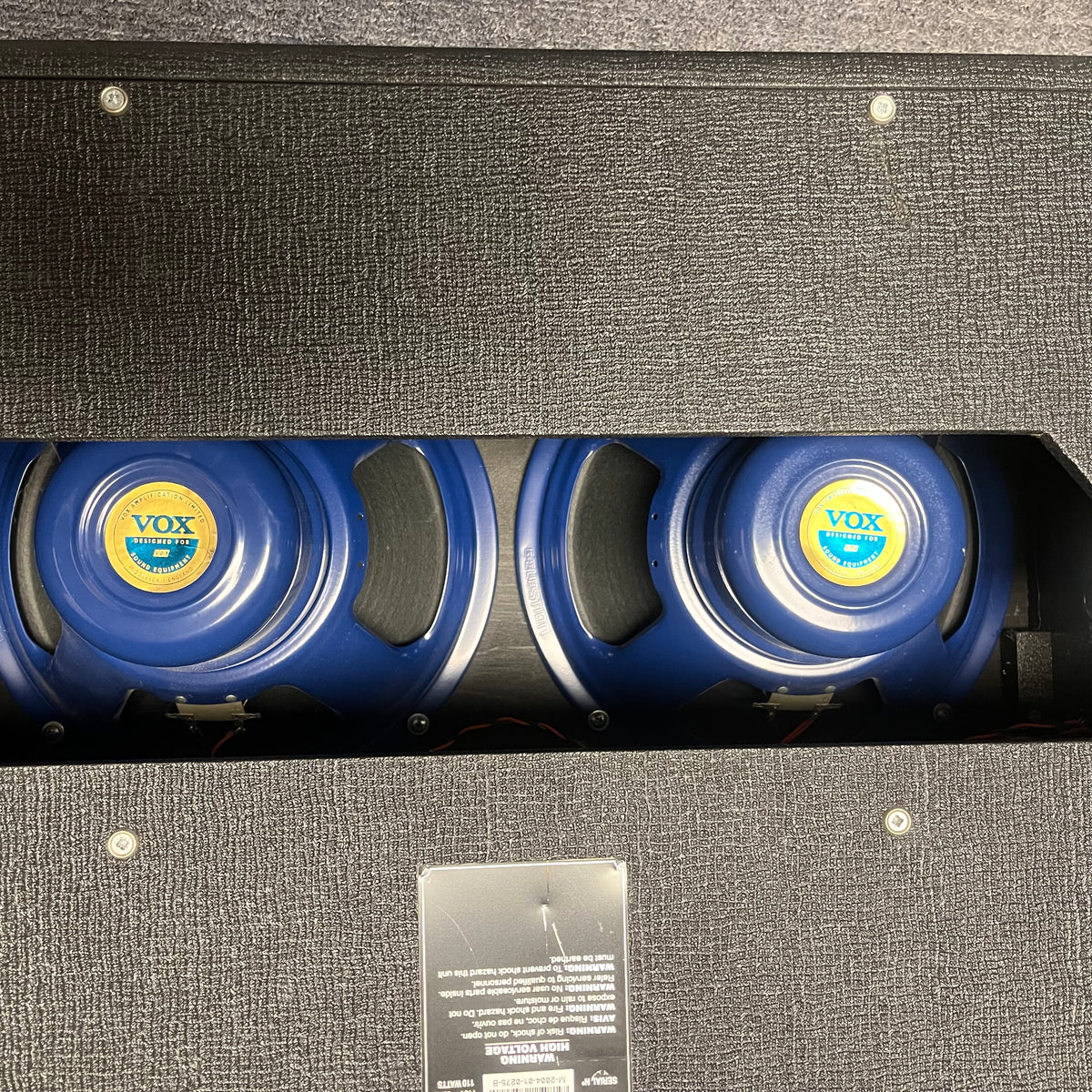 Rear view of a 2004 Vox AC30/6TB guitar amp by Vox, made in England, showing three Celestion Alnico Blues speakers through the open back of the black cabinet.