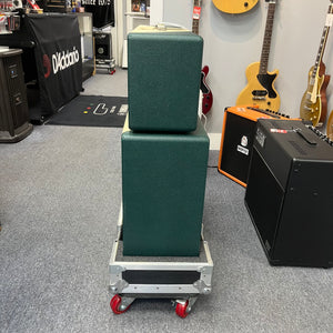 A 2005 Divided by 13 RSA 31 head with matching 2x12 cabinet and flight case is stacked on a metal rolling cart inside a music store, with guitars and amplifiers visible in the background. Local pickup only.