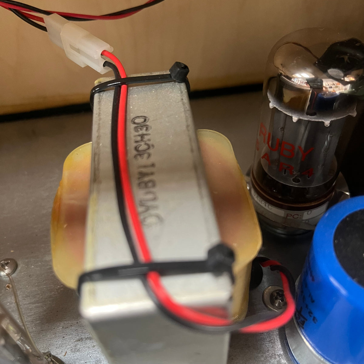 Close-up of electronic components including a tube, with a blurred background.