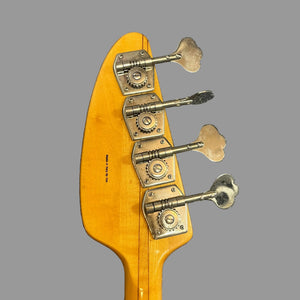 Close-up of the back of a 1967-68 Vox Sidewinder IV Bass (V272) Cherry headstock by Vox, featuring four silver tuning pegs against a plain gray background.