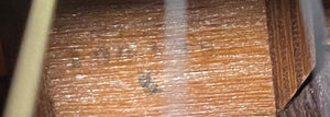 Close-up of the textured brown wood surface with faint black markings and a white streak, echoing the craftsmanship found on the Sigma Vintage DR-35 Acoustic Guitar w/case (Made in Japan).