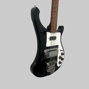 A Rickenbacker 4003 Bass Guitar – 2020 Jetglo w/Case, featuring a black finish with a white pickguard and chrome hardware, is mounted on a white wall next to a red electric guitar. Its Jetglo finish and classic Rickenbacker design evoke an iconic vintage style.