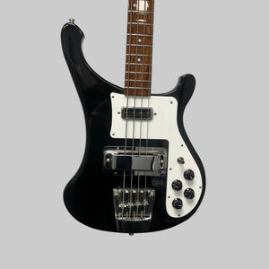 A Rickenbacker 4003 Bass Guitar – 2020 Jetglo w/Case featuring a black finish, four strings, white pickguard, chrome bridge, and control knobs is hanging on a light gray wall.