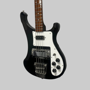 A Rickenbacker 4003 Bass Guitar – 2020 Jetglo w/Case, featuring a black and white finish, four strings, chrome hardware, and four control knobs, is mounted on a gray wall.