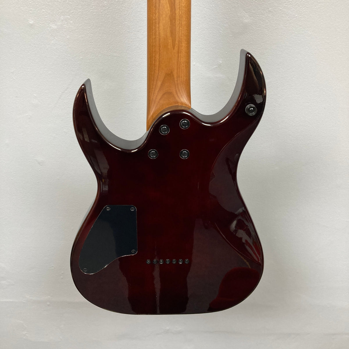 Spira S-457 TPP&#39;s rear view shows its glossy dark-red body, double-cutaway design, and electronics cavity cover, highlighting its precision build.