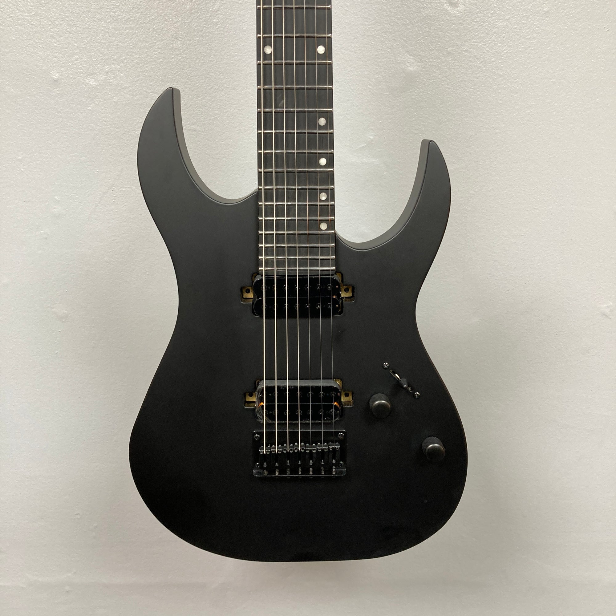 Spira S-407 MBK Matte Black Electric Guitar, featuring seven strings, dual humbuckers, and satin finish, showcasing sleek design and extended range for versatile playability.