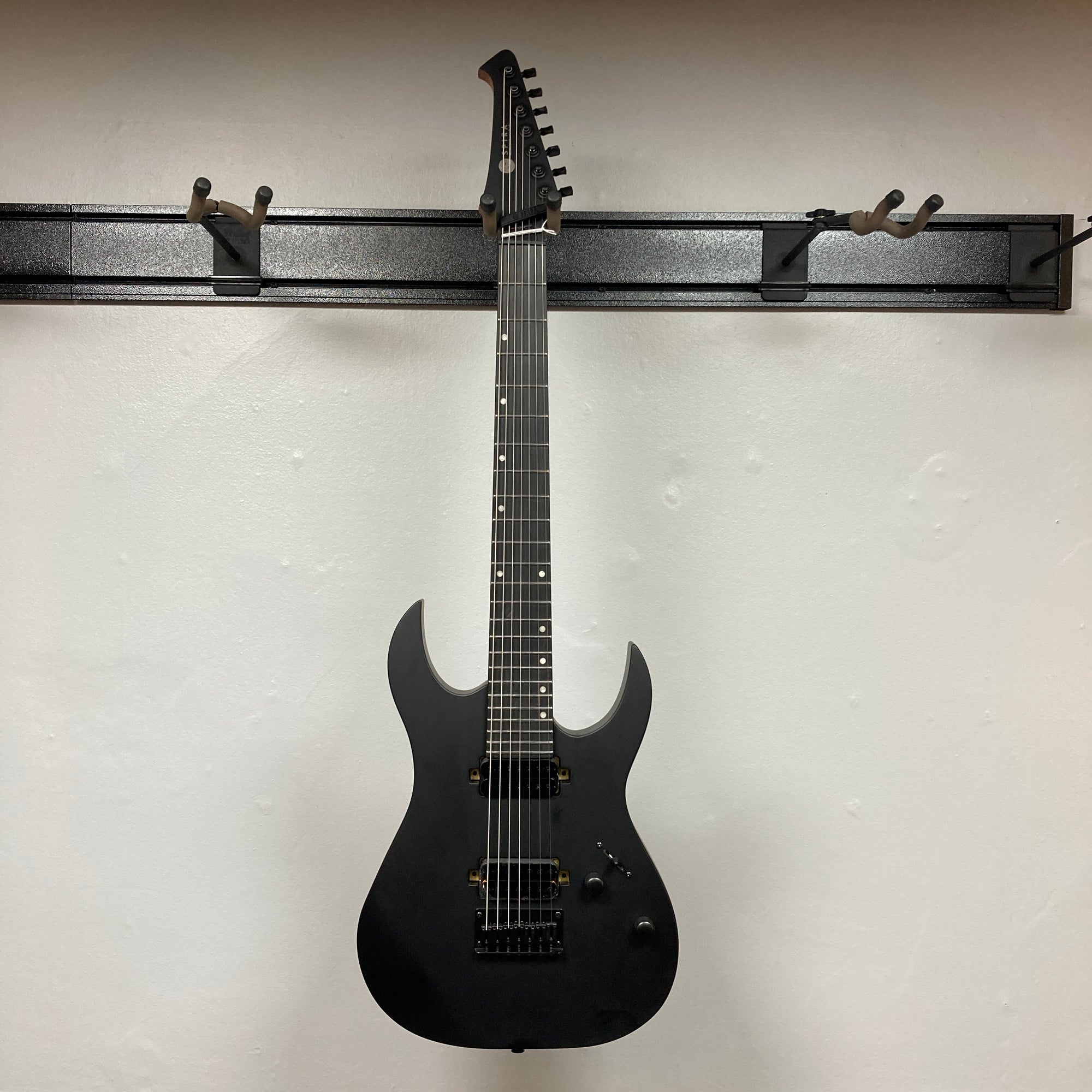 Spira S-407 MBK Matte Black Electric Guitar, featuring seven strings, dual humbuckers, and satin finish, showcasing sleek design and extended range for versatile playability.