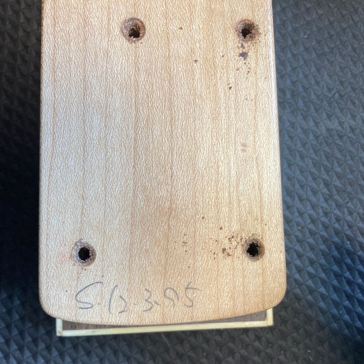 A close-up of the ESP Standard Eclipse Transparent Cherry Red guitar body by Esp, showing four drilled holes and "CL 395" handwritten at the bottom, set against a textured dark background.