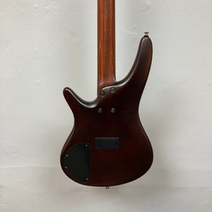 Back view of an Ibanez SDGR SR500PB w/Hard case bass guitar in dark brown, showing its smooth finish, visible neck, control cavity cover, and mounting screws against a plain light background.