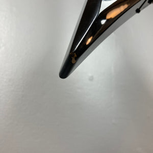 Close-up of the tip of a 1992 Carvin Ultra V USA – Kahler Steeler Trem, MJ-Wound Seymour Duncan DCJ guitar with a small chipped area showing a lighter color underneath, set against a plain white background.