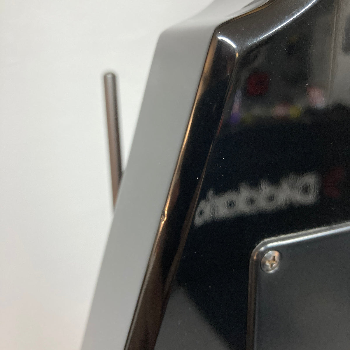 Close-up of a glossy black Carvin 1992 Ultra V USA, with a metal antenna and blurred reflection—echoing the precision of its Kahler Steeler Trem and MJ‑wound Seymour Duncan DCJ pickups.