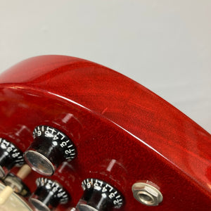 Close-up of a Gibson SG Standard Heritage Cherry yr 2000 Consign, featuring black and silver control knobs and a metal input jack, set against a plain background.