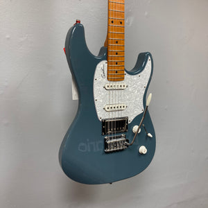 The Godin Session T-Pro Arctik Blue MN SF with Bag is a blue electric guitar featuring a maple neck, white pickguard, Seymour Duncan HSS pickups, tremolo bridge, and control knobs. Displayed against a plain gray wall.