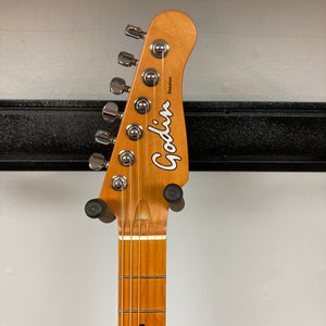 Close-up of a Godin Session T-Pro Arctik Blue MN SF with Bag headstock, showing six tuning pegs and the Godin logo on a wood finish, plus part of a wall-mounted holder. Features HSS Seymour Duncan pickups.