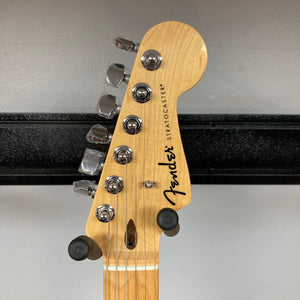 Close-up of a Fender Standard Stratocaster Olympic White Refurb headstock, featuring the Fender logo, tuning pegs, and string guides against a neutral background.