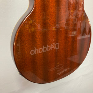 Close-up of the back of a Dean Boca Trans Amber Burst 12 String guitar showing a scratch on the wood finish and reflected text.