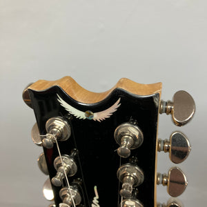 Close-up of a Dean Boca Trans Amber Burst 12 String headstock with twelve tuning pegs and an inlaid white bird design, ideal for fans of the semi hollow body guitar style. Includes gigbag.