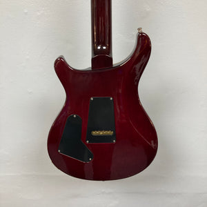The back of a PRS Custom 24 Violet 2011 electric guitar by PRS is shown with two black plastic covers and a glossy finish, displayed against a plain white background.