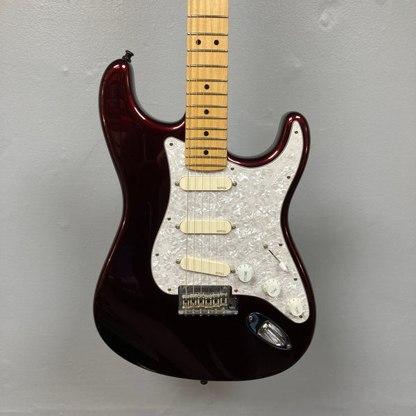 Fender American Standard Strat upgraded Gilmour EMG DC-20 Bordeaux Metallic electric guitar with a dark red Bordeaux Metallic finish, three EMG DG20 David Gilmour pickups, white pickguard, and maple neck hanging against a plain gray wall.
