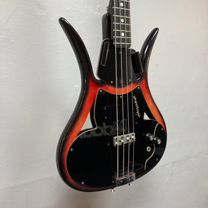Vintage bass enthusiasts will appreciate the 1966 Ampeg ASB-1 Devil Bass Serial #531, featuring a striking sunburst and black finish, two pickups—including a distinctive bridge-mounted transducer pickup—and a signature on the pickguard, elegantly displayed on a light-colored wall.