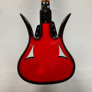 The back of an Ampeg 1966 ASB-1 Devil Bass (Serial #531) with a glossy red finish, distinctive curved horns, and two f-shaped sound holes is shown against a plain light-colored wall.