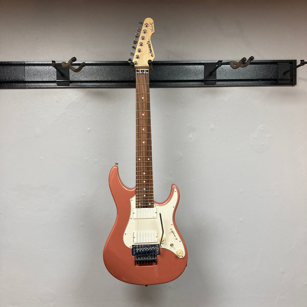 An Edwards E-SN7-194MF Mikio Fujioka Signature Burgundy Mist electric guitar with white pickups, a white pickguard, a whammy bar, and a rosewood fretboard, hanging against a light gray wall. This eye-catching seven-string guitar from Edwards is modeled after the Mikio Fujioka Signature 7-String model.