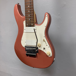 An Edwards E-SN7-194MF Mikio Fujioka Signature Burgundy Mist 7-string electric guitar, featuring a metallic red finish, white pickguard, two control knobs, and a whammy bar, is mounted on a wall with a plain light gray background.