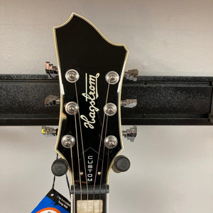 The headstock of the Hagstrom Fantomen Custom Black w/case electric guitar by Hagstrom features six tuning pegs, a silver logo, and “CUSTOM” written vertically.