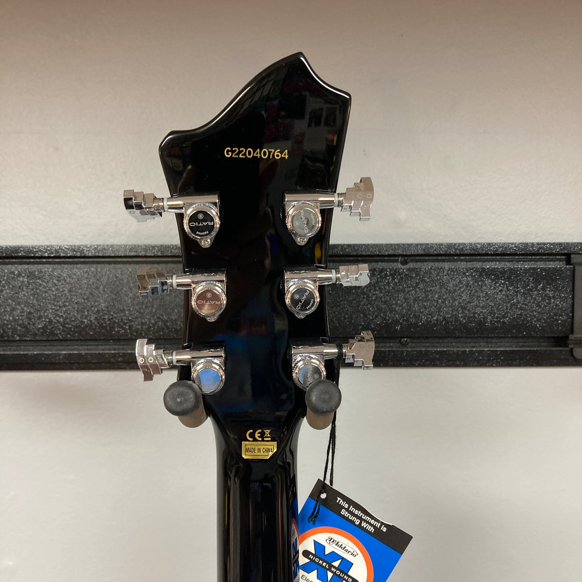 Back of a Hagstrom Fantomen Custom Black w/case guitar headstock showing chrome tuning pegs, serial number G22040764, manufacturer label, and a hanging tag—highlighting the neck-through electric guitar construction and premium Lundgren Design humbuckers from Hagstrom.