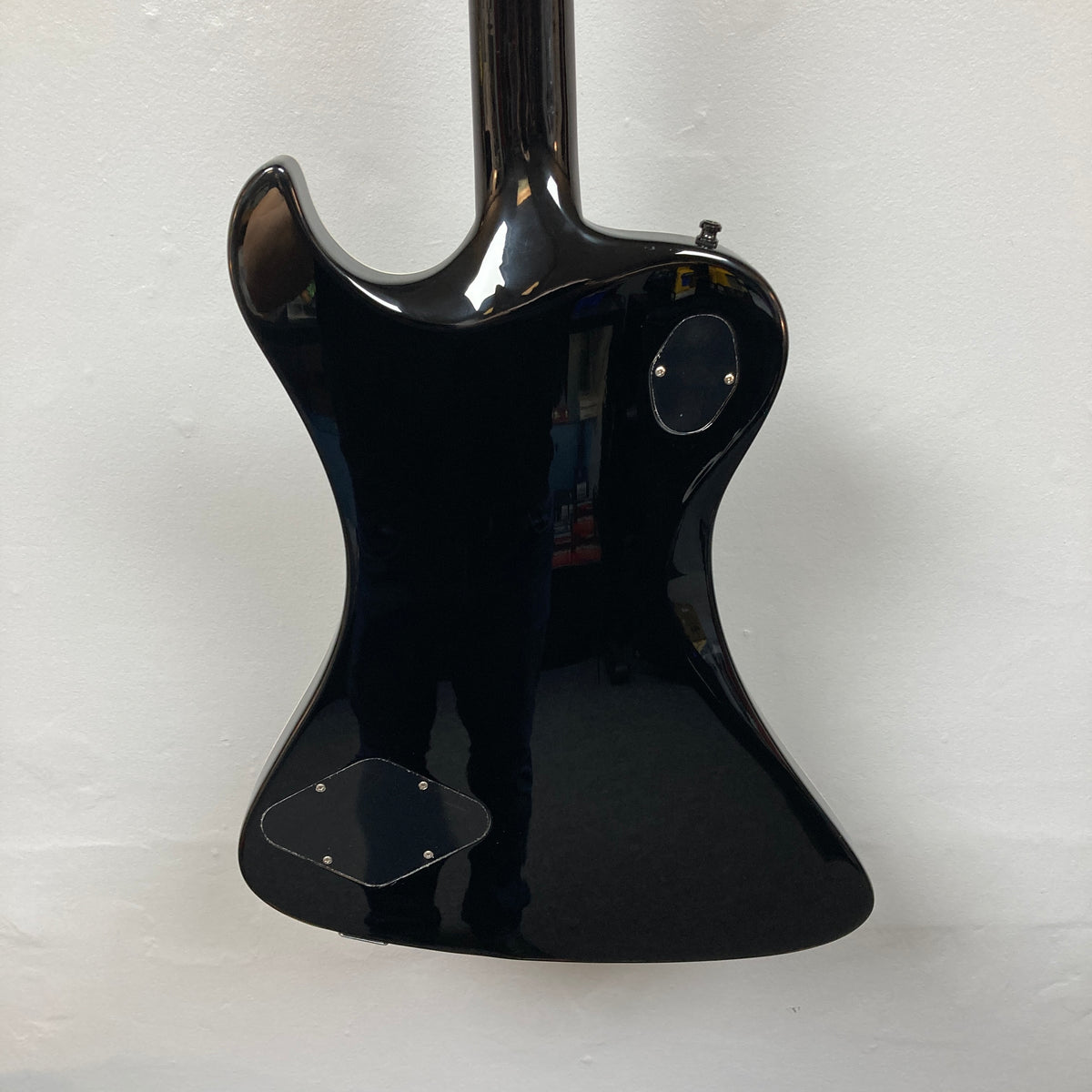 The back of a Hagstrom Fantomen Custom Black electric guitar with two access panels, photographed against a plain white wall.