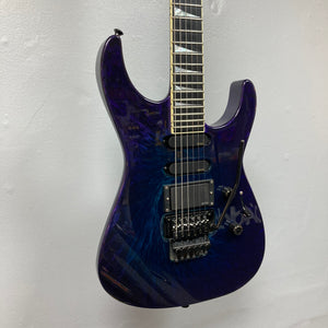 Featuring a mesmerizing Eerie Dess Swirl finish in dark blue with a glossy sheen, the 1995 Jackson SL1 Soloist Custom Shop electric guitar boasts two humbucker pickups, a locking tremolo bridge, and sleek black hardware. This exceptional Jackson instrument comes complete with its case and is captured here against a plain white wall.