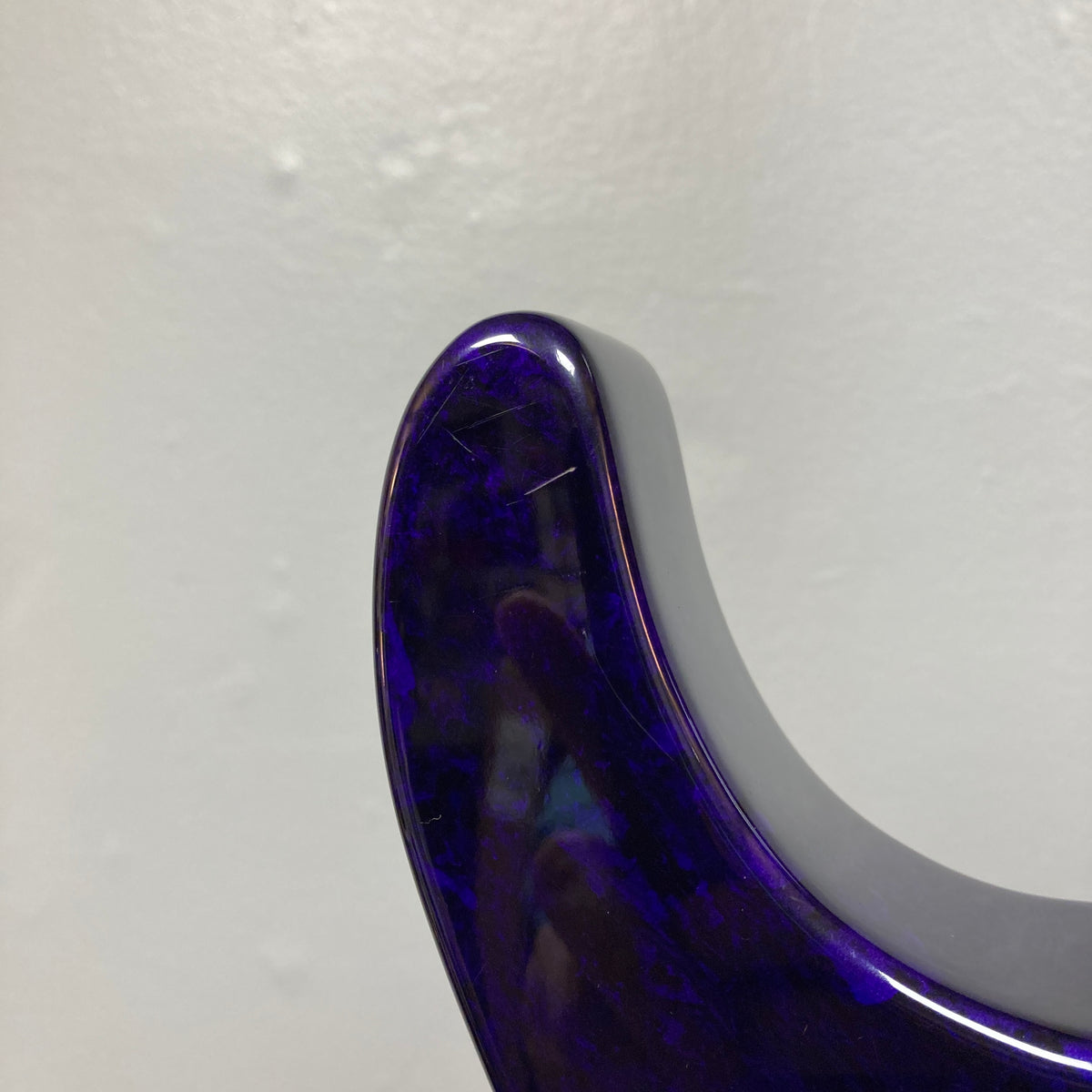 Close-up of the upper horn of a Jackson 1995 SL1 Soloist Custom Shop electric guitar in Eerie Dess Swirl finish, set against a plain light gray wall.