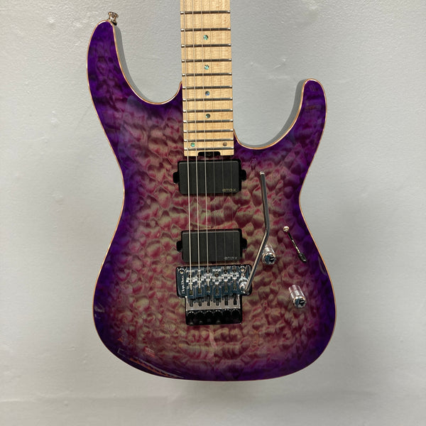 The 2019 ESP USA M-II Purple Haze Burst w/Case, crafted in the USA by ESP, features a stunning quilted maple top in Purple Haze Burst, two black humbucker pickups, a maple fretboard, and a Floyd Rose tremolo bridge—photographed here against a plain light gray wall.