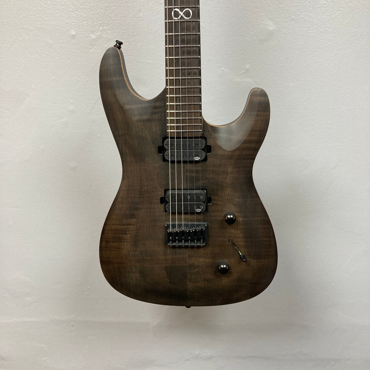 Chapman ML1 Pro Modern Lunar electric guitar by Chapman, featuring a dark wood finish, dual humbucker pickups, 24-fret neck, two control knobs, and a switch, photographed against a plain white wall.