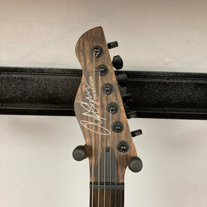 Close-up of a Chapman ML1 Pro Modern Lunar electric guitar headstock featuring six tuning pegs, strings, and the “Chapman” signature on a woodgrain finish background.