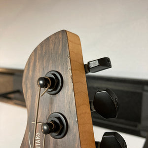 Close-up of the Chapman ML1 Pro Modern Lunar headstock by Chapman, highlighting the tuning pegs, wood finish, and a noticeable scratch or crack along the edge.