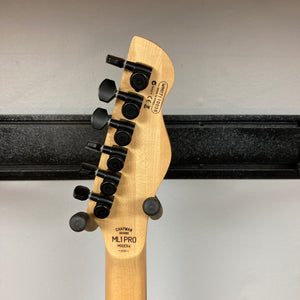 The back of a Chapman ML1 Pro Modern Lunar electric guitar headstock with six black tuning pegs, displaying model and serial number details, photographed against a white wall and black horizontal rack.