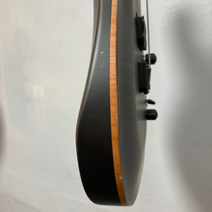 Side view of the Chapman ML1 Pro Modern Lunar electric guitar by Chapman, showcasing its natural wood edge, 24-fret neck, dual humbucker pickups, and black control knobs—all set against a light-colored wall.